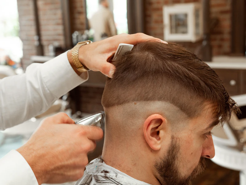 Barber finishing a clipper fade